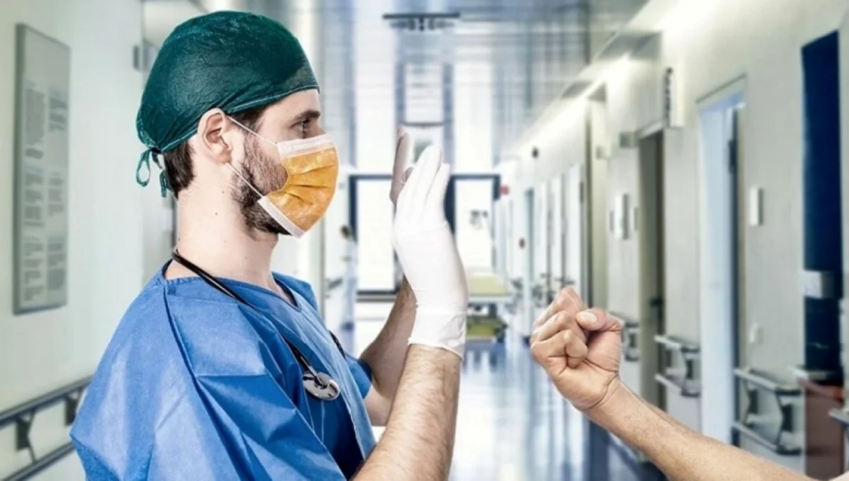 Infermiere con mani alzate minacciato con un pugno